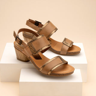 Pair of tan sandals with gold accents on a beige background