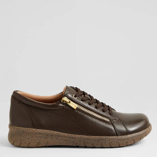 Brown leather shoe with a gold zipper on a light gray background